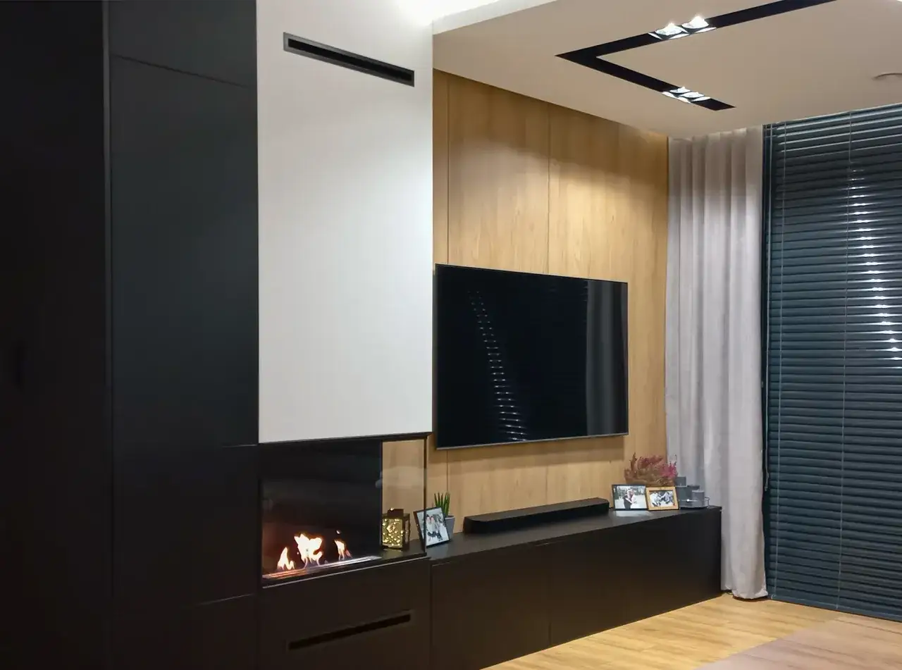 Nowoczesny salon z biokominkiem do zabudowy, czarną szafką RTV i drewnianą ścianą.