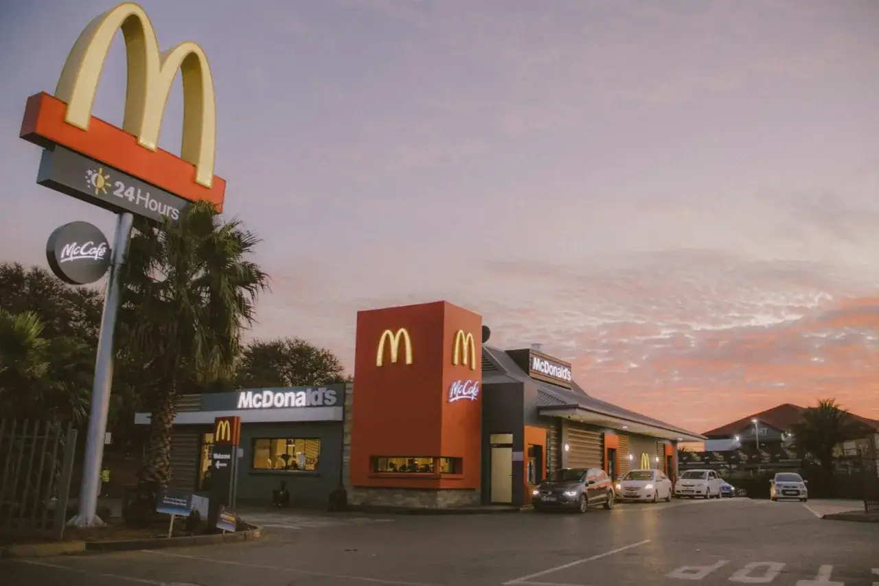 Zachód słońca nad McDonald's. Zastanawiasz się, ile kosztuje franczyza McDonald's? To miejsce oferuje McCafe i jest otwarte 24h.