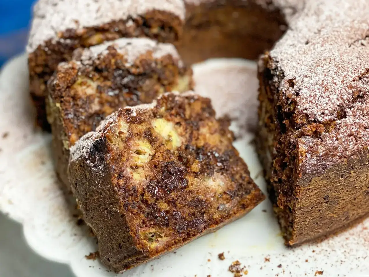 Pyszne ciasto kręcone z bananami i czekoladą, posypane cukrem pudrem. Idealne na deser lub podwieczorek.