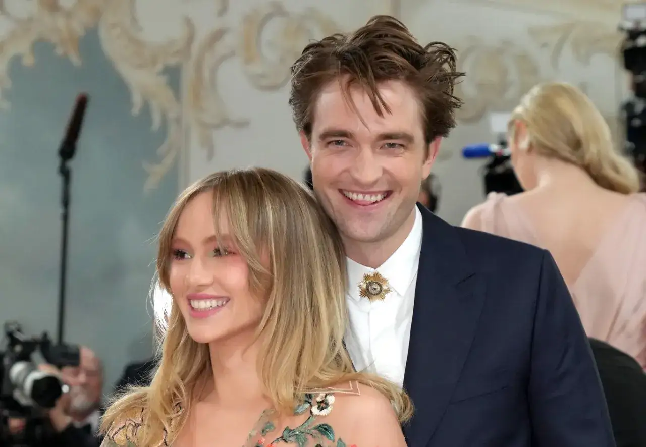 Uśmiechnięty Robert Pattinson, jakby był szczęśliwym dzieckiem, pozuje z ukochaną.
