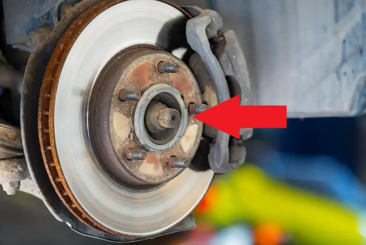 Czerwona strzałka wskazuje na piastę koła z widocznym za małym otworem centrującym felgi, co może powodować problemy z montażem.