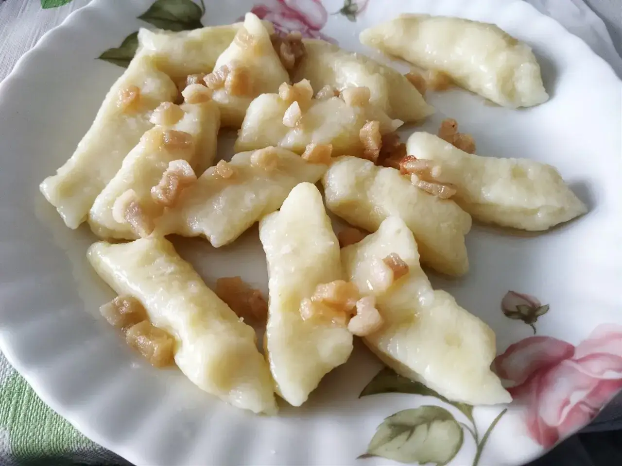 Pyszne kluski leniwe z ugotowanych ziemniak&oacute;w, posypane skwarkami. Idealny pomysł, co zrobić z ugotowanych ziemniak&oacute;w na szybki obiad.