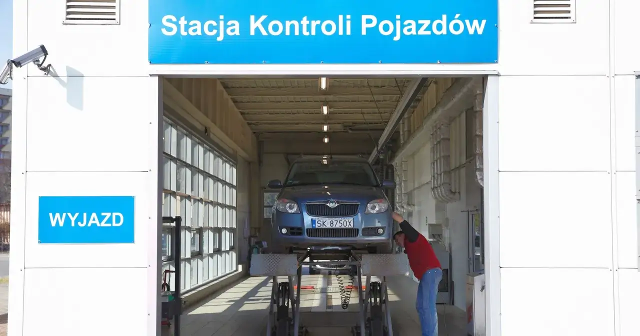 Pracownik sprawdza samochód na podnośniku w stacji kontroli pojazdów. Dowiedz się, ile kosztuje przegląd rejestracyjny.