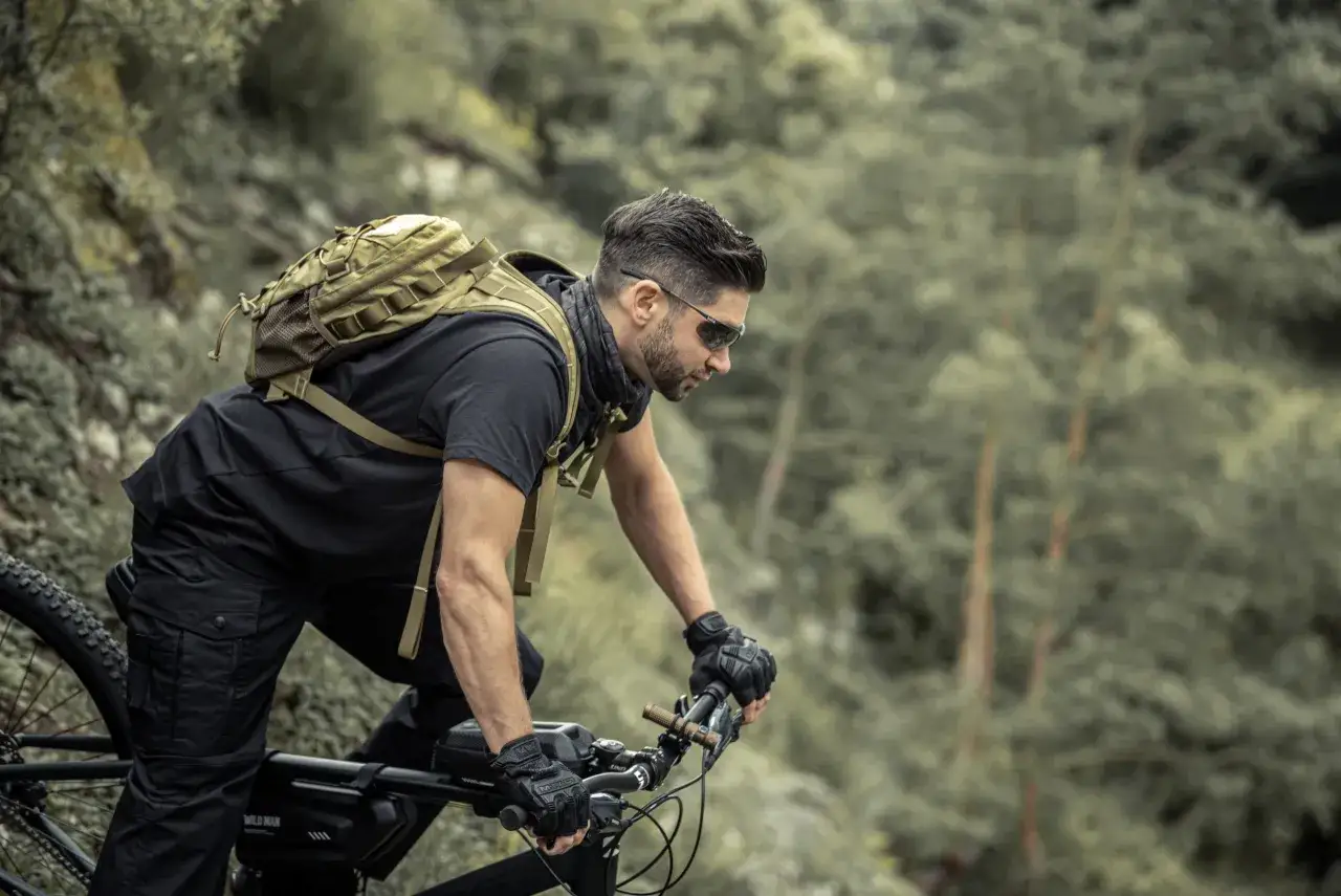 Mężczyzna w okularach na rowerze, z plecakiem, przemierza leśny szlak. Dobre okulary na rower to podstawa!