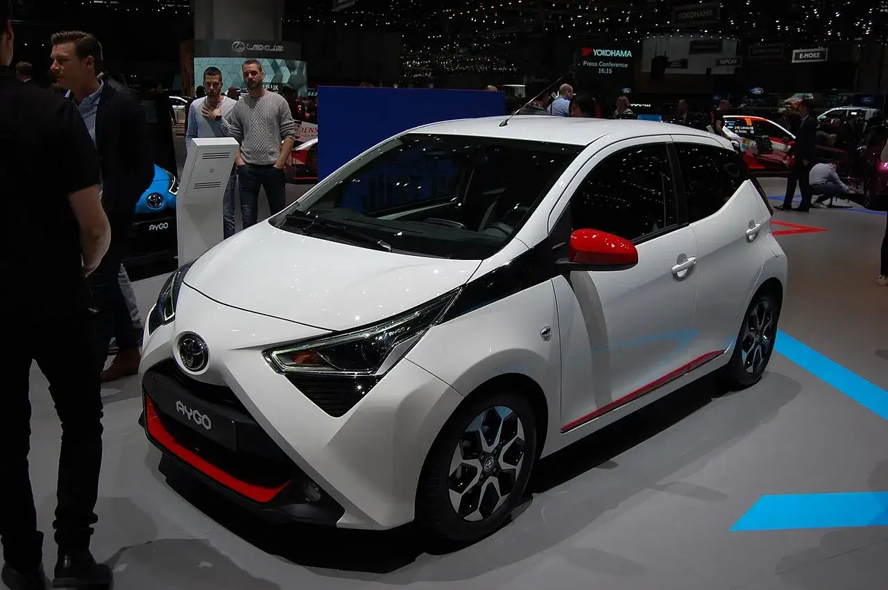 Biała Toyota Aygo z czerwonymi akcentami na wystawie. Zastanawiasz się, ile pali Toyota Aygo? Ten miejski samochód jest znany z niskiego spalania.