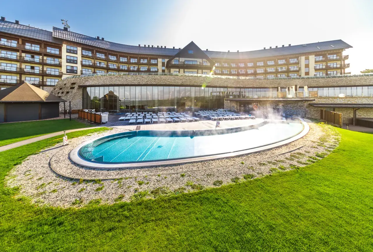 Nowoczesny hotel w Bieszczadach z basenem zewnętrznym i leżakami.