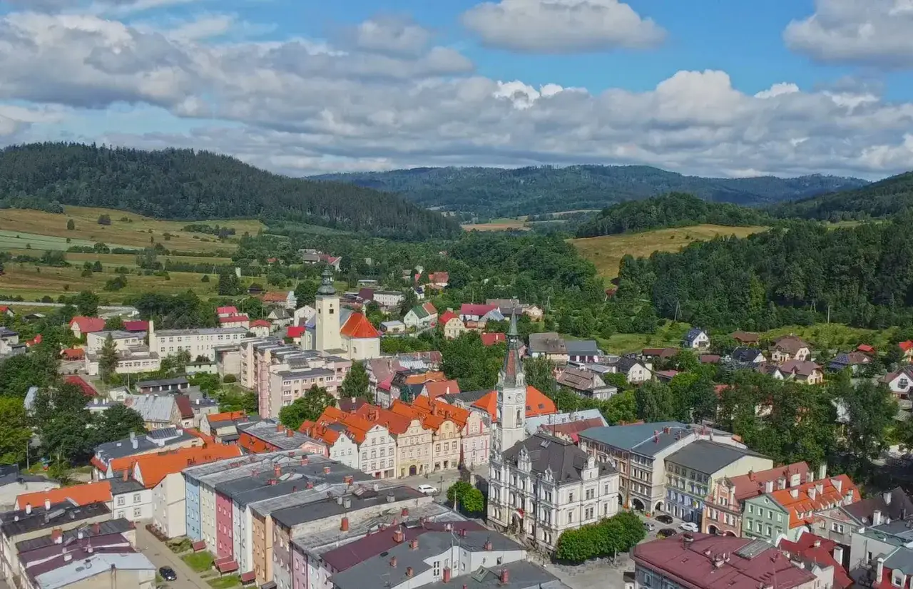 Widok na Lądek Zdr&oacute;j z g&oacute;rami w tle. Kolorowe kamienice i kościoły tworzą urokliwe lądek zdr&oacute;j atrakcje.
