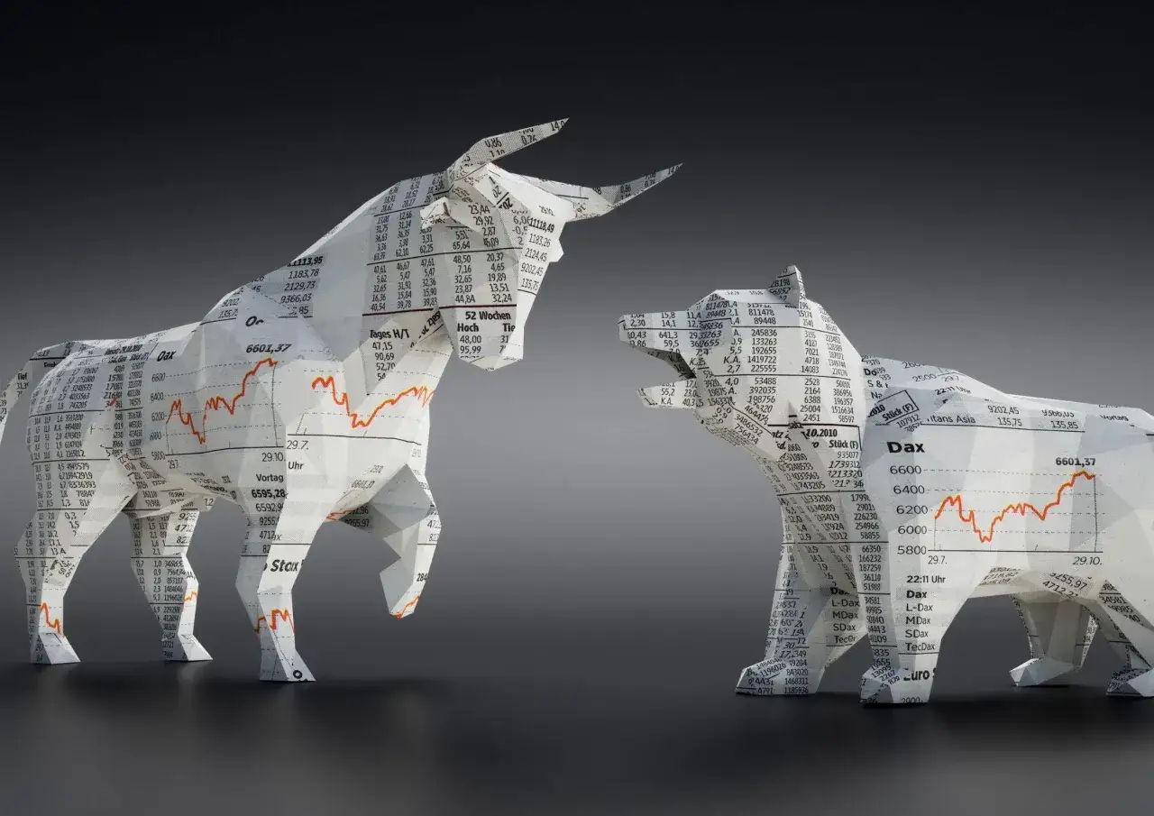 Byk symbolizuje hossę, bo jego r&oacute;g atakuje w g&oacute;rę, jak wzrosty na giełdzie. Papierowe figury byka i niedźwiedzia na tle wykres&oacute;w.