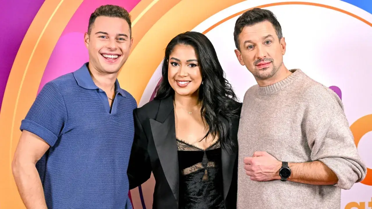 Trzy uśmiechnięte osoby pozują do zdjęcia. Kiedy usłyszą muzykę, na pewno zaczną tańczyć!