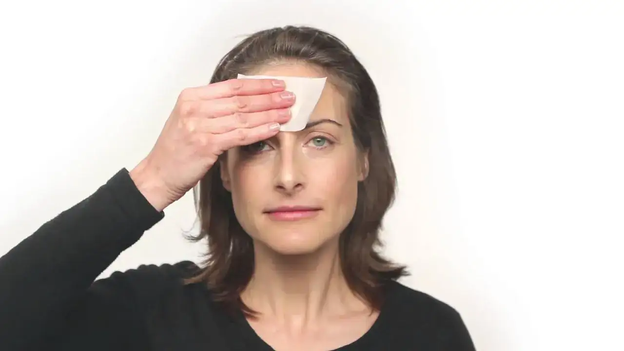 kobieta wykonująca test z bibułką matującą na twarzy