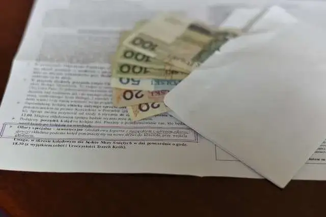 koperta z pieniędzmi wręczana księdzu w kancelarii parafialnej