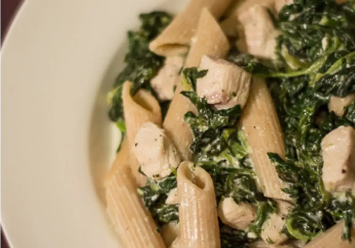 Penne z kurczakiem, szpinakiem i fetą w kremowym sosie. Pyszne danie pełne smaku.