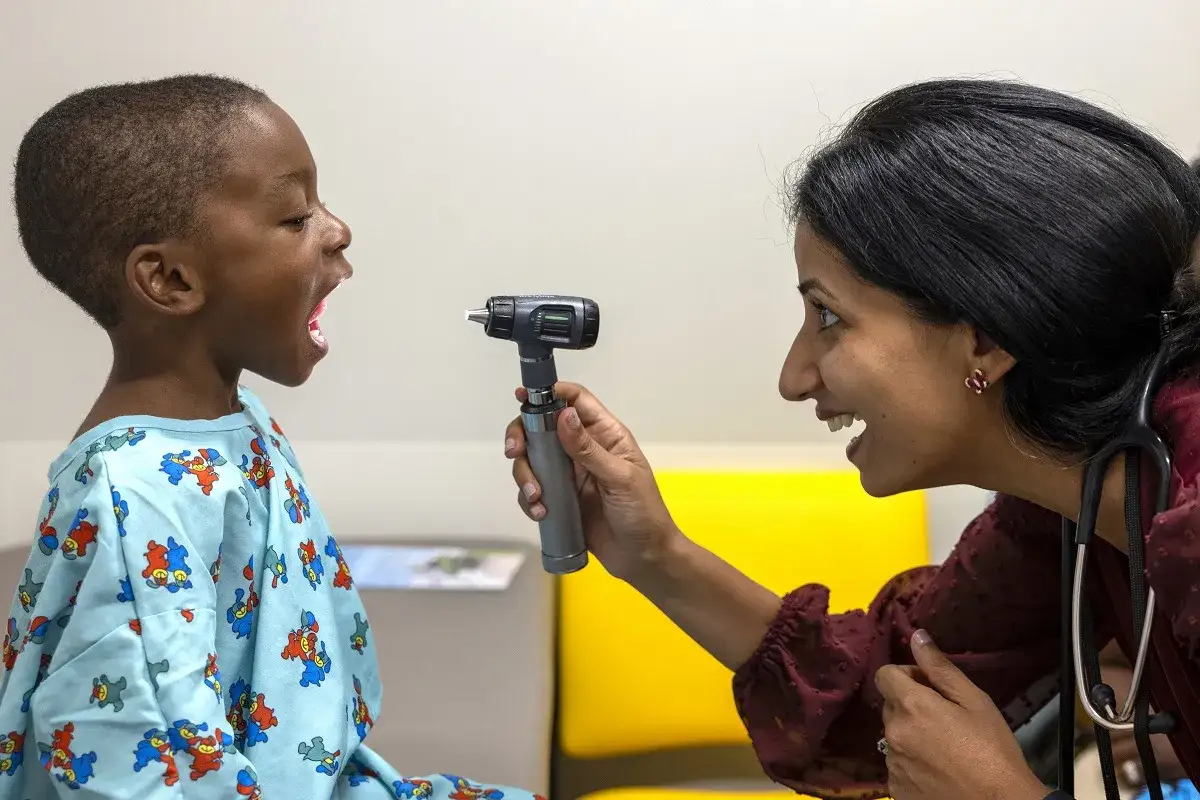 Lekarka bada gardło chłopca. Gdy boli gardło, warto znać domowe sposoby na ulgę.