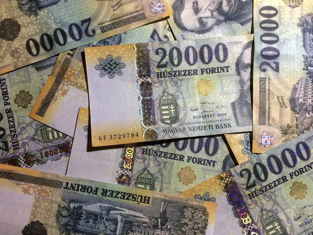 Stos banknot&oacute;w 20 000 forint&oacute;w, węgierska waluta. Widoczne portrety i budynki.