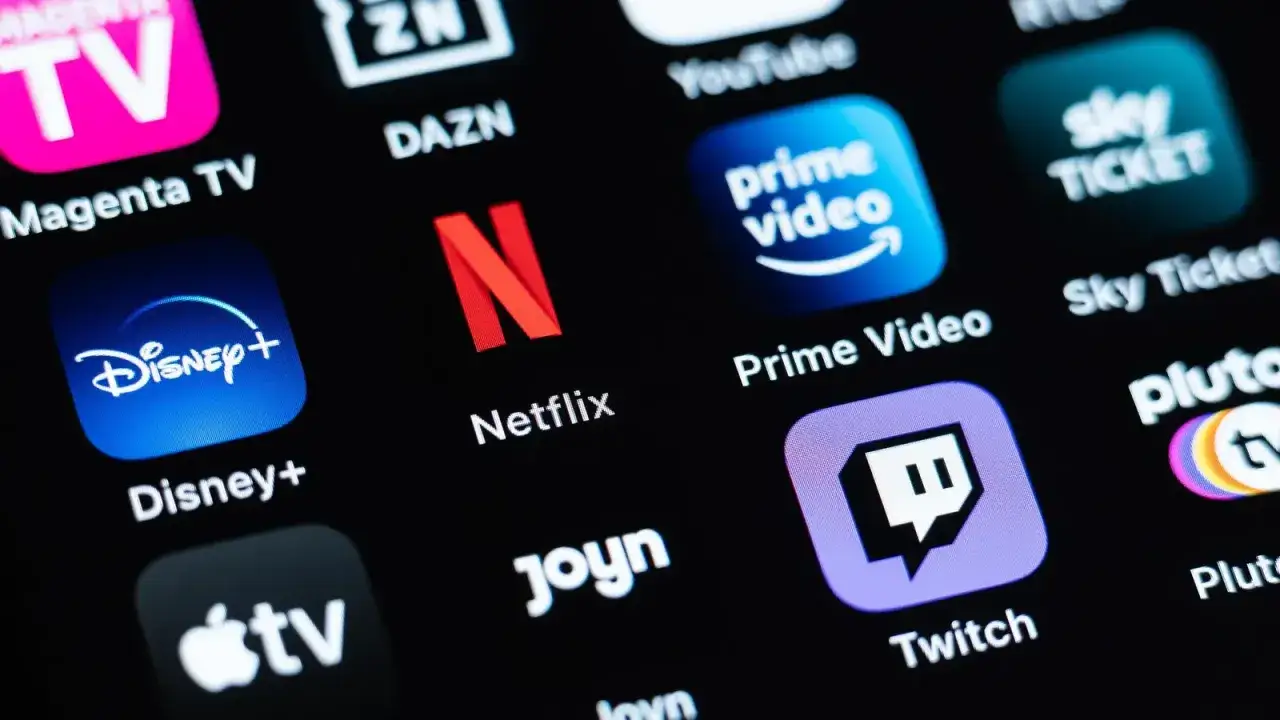 Ekran smartfona z ikonami platform streamingowych: Netflix, Disney+, Prime Video, Twitch i innymi. Wybór najlepszej platformy streamingowej zależy od preferencji.