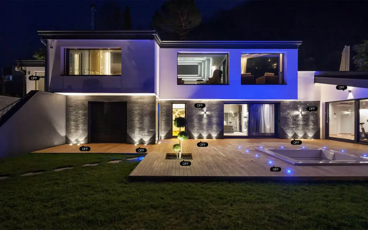 Nowoczesny dom z tarasem i basenem, oświetlony nocą. Tuya automatyzacja pozwala sterować każdym światłem, tworząc idealną atmosferę.
