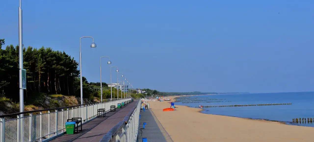 Promenada nad morzem, sosnowy las i plaża. Czy Mielno to miasto? Wygląda jak kurort, ale ma urok miejskiego deptaka.