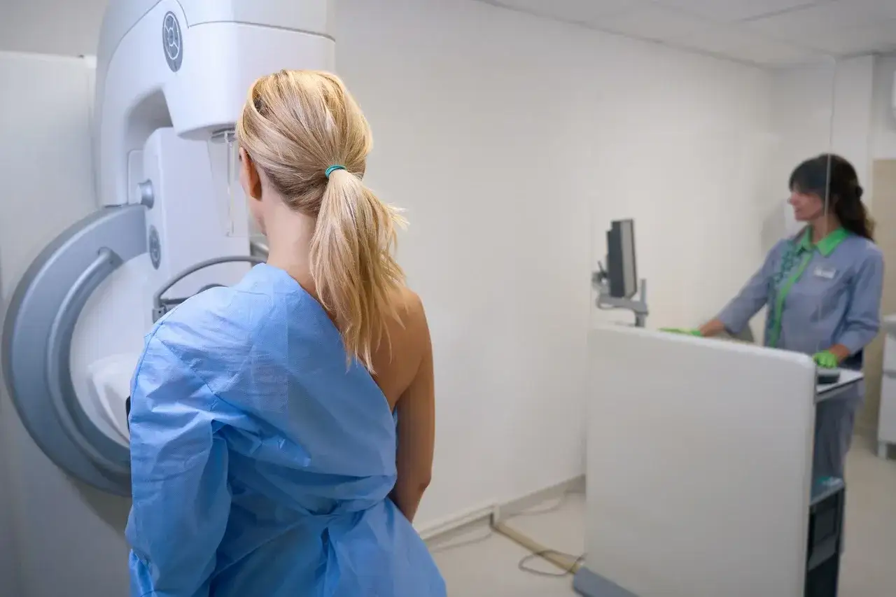 Kobieta przygotowuje się do mammografii. Czy mammografia boli? To badanie jest kluczowe dla wczesnego wykrywania raka piersi.