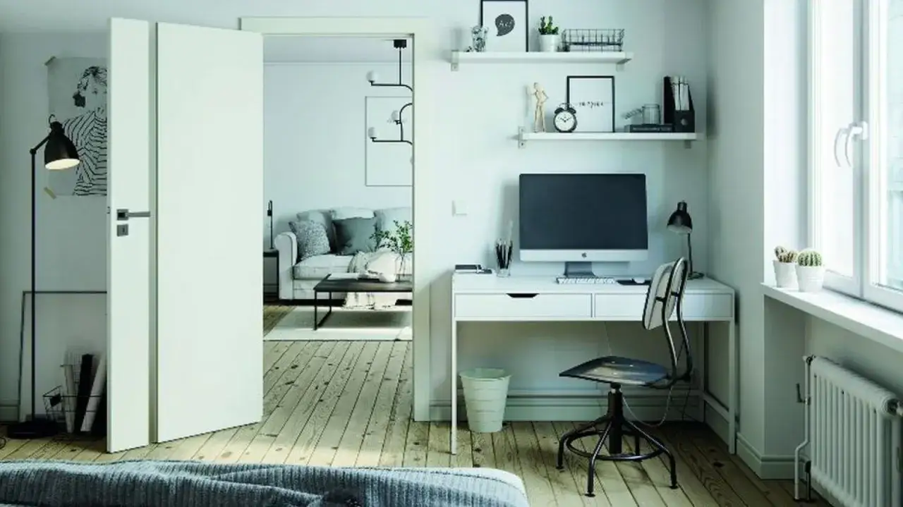 Nowoczesny gabinet w domu z biurkiem, komputerem i wygodnym fotelem. Obok widać salon z sofą.