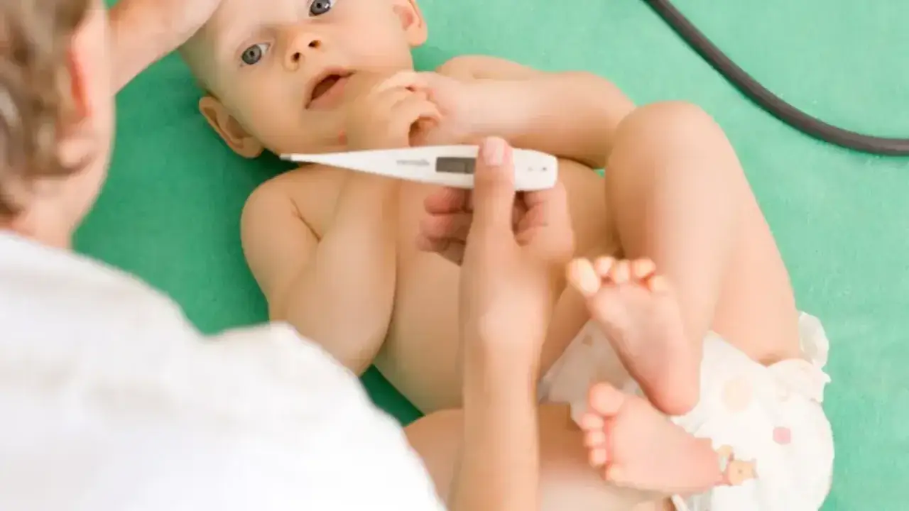 Lekarz mierzy temperaturę niemowlęciu, które może mieć powikłania po RSV.