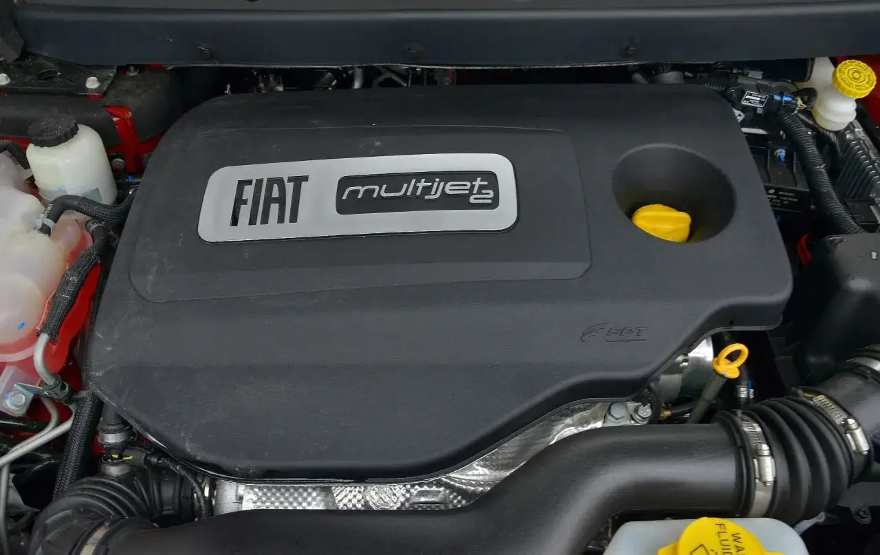 Silnik MultiJet w Fiat Freemont. Widoczna czarna osłona z logo Fiat i MultiJet, żółty korek wlewu oleju.