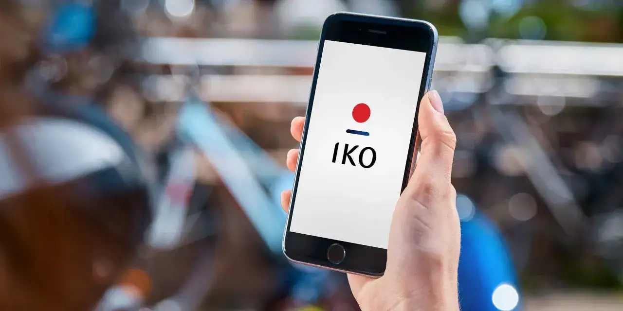 Dłoń trzyma smartfon z logo IKO. Dowiedz się, jak zalogować się do aplikacji IKO na nowym telefonie.