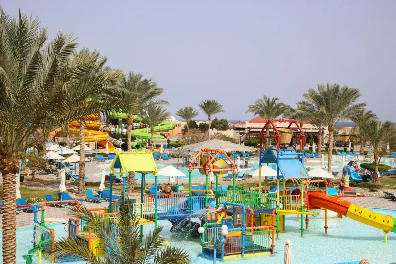 Kolorowy park wodny z palmami i zjeżdżalniami. Idealne miejsce na wakacje all inclusive soft, co znaczy beztroski relaks i zabawa dla całej rodziny.