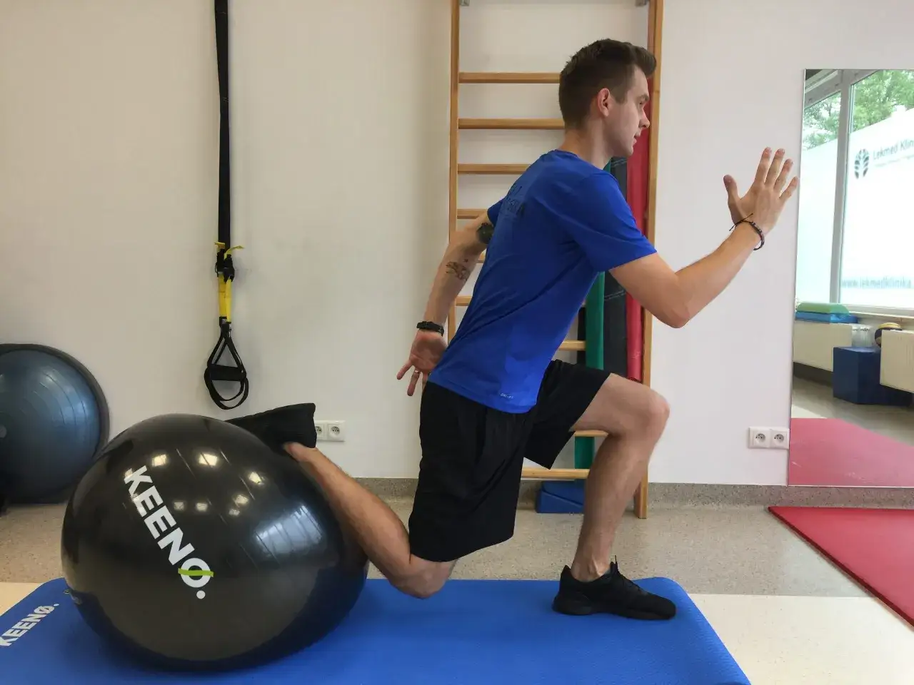 Mężczyzna wykonuje ćwiczenie z piłką, co może być częścią rehabilitacji po zabiegu, np. czy po kwasie hialuronowym w kolano można ćwiczyć.