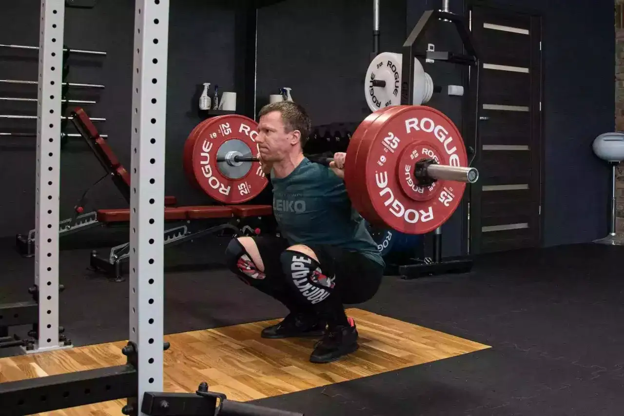 Osoba wykonująca przysiady ze sztangą