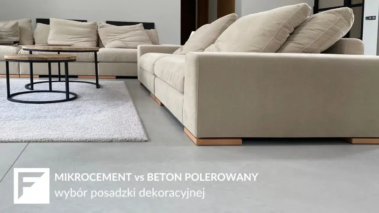 Nowoczesna podłoga z mikrocementu w salonie, obok jasnej kanapy i dywanu.