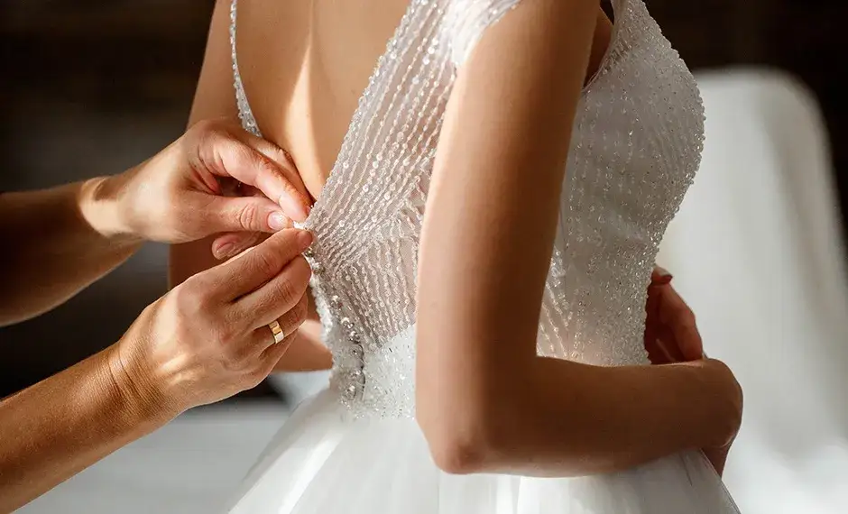 Panna młoda przymierzająca suknię ślubną w salonie