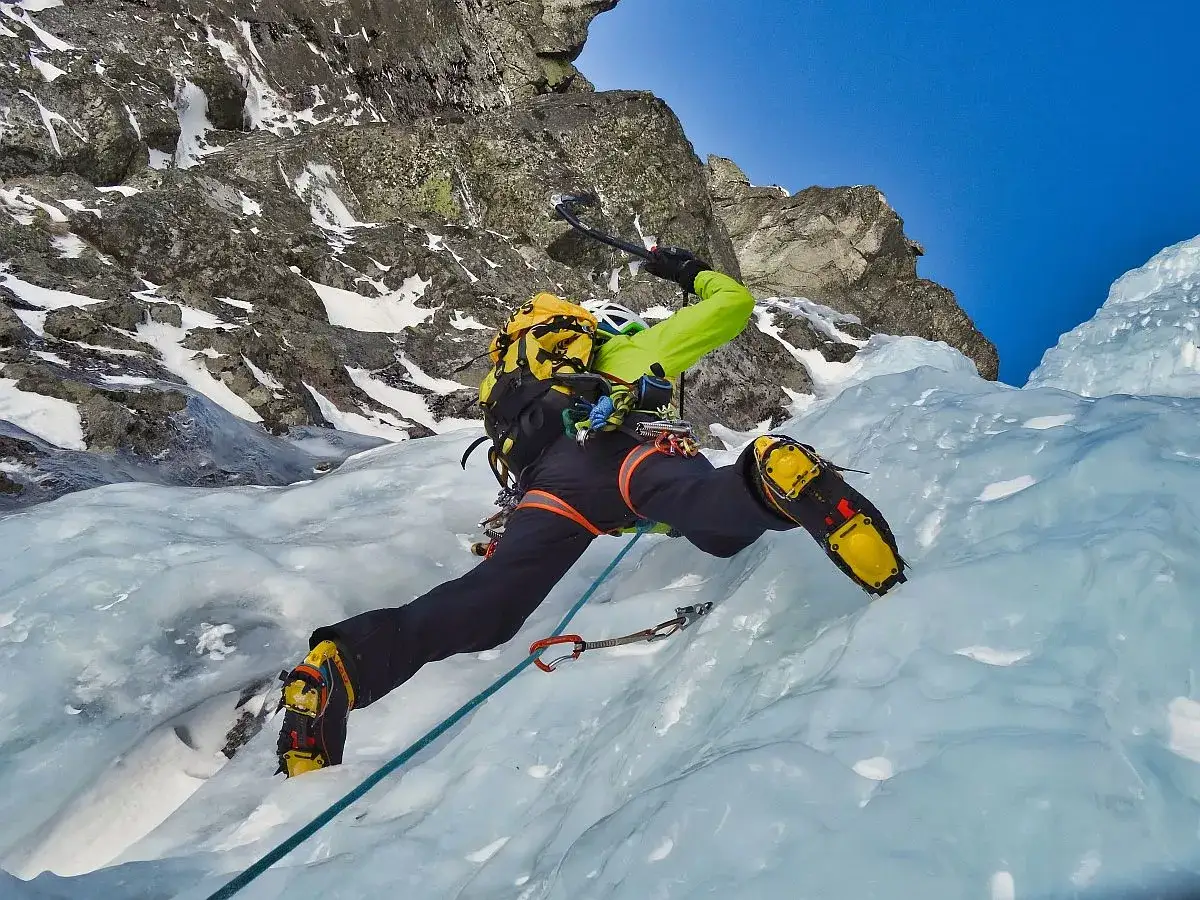 Wspinaczka po lodospadzie w Tatrach. Widoczna lina, czekany i raki. Skala taternicka w akcji.