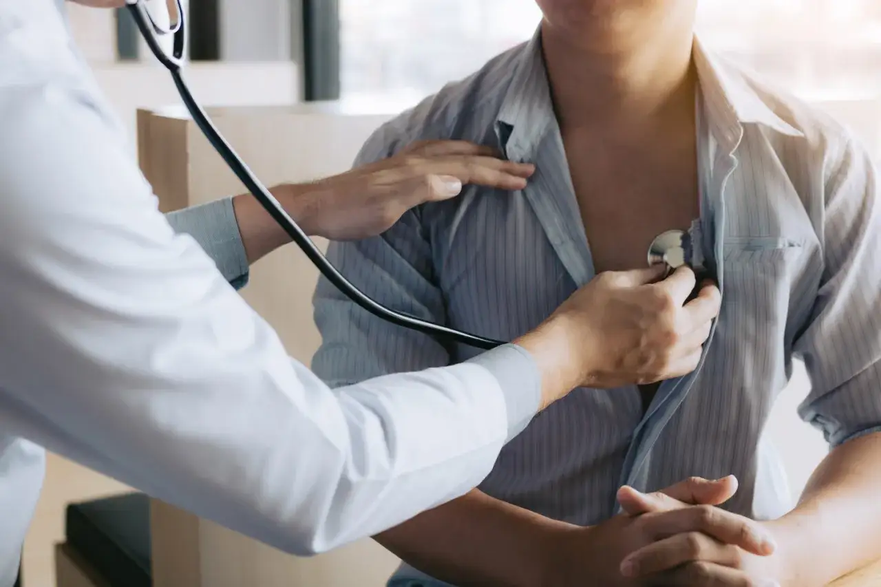 Lekarz medycyny pracy osłuchuje pacjenta stetoskopem. Wizyta trwa krótko, ale jest ważna dla oceny stanu zdrowia.