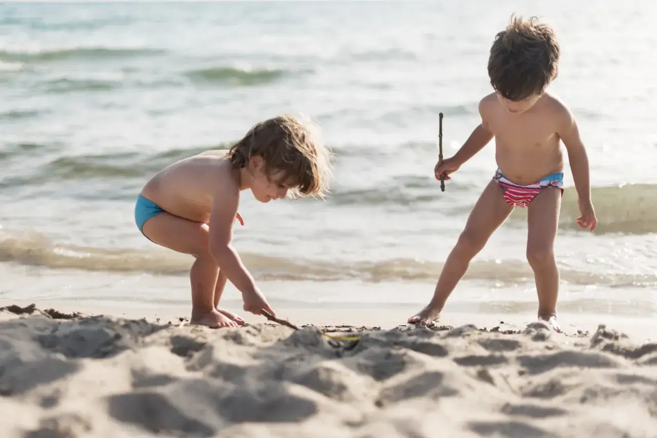 Dzieci budują zamek z piasku na plaży. Władysławowo atrakcje dla dzieci to świetna zabawa nad morzem.