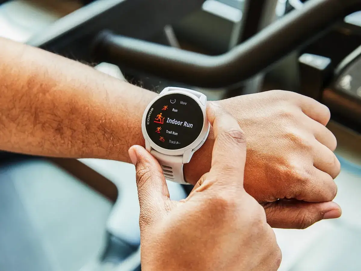 Dłoń z zegarkiem sportowym, na kt&oacute;rym widać opcje biegu. Zegarek pomoże Ci jak obliczyć tempo biegu.