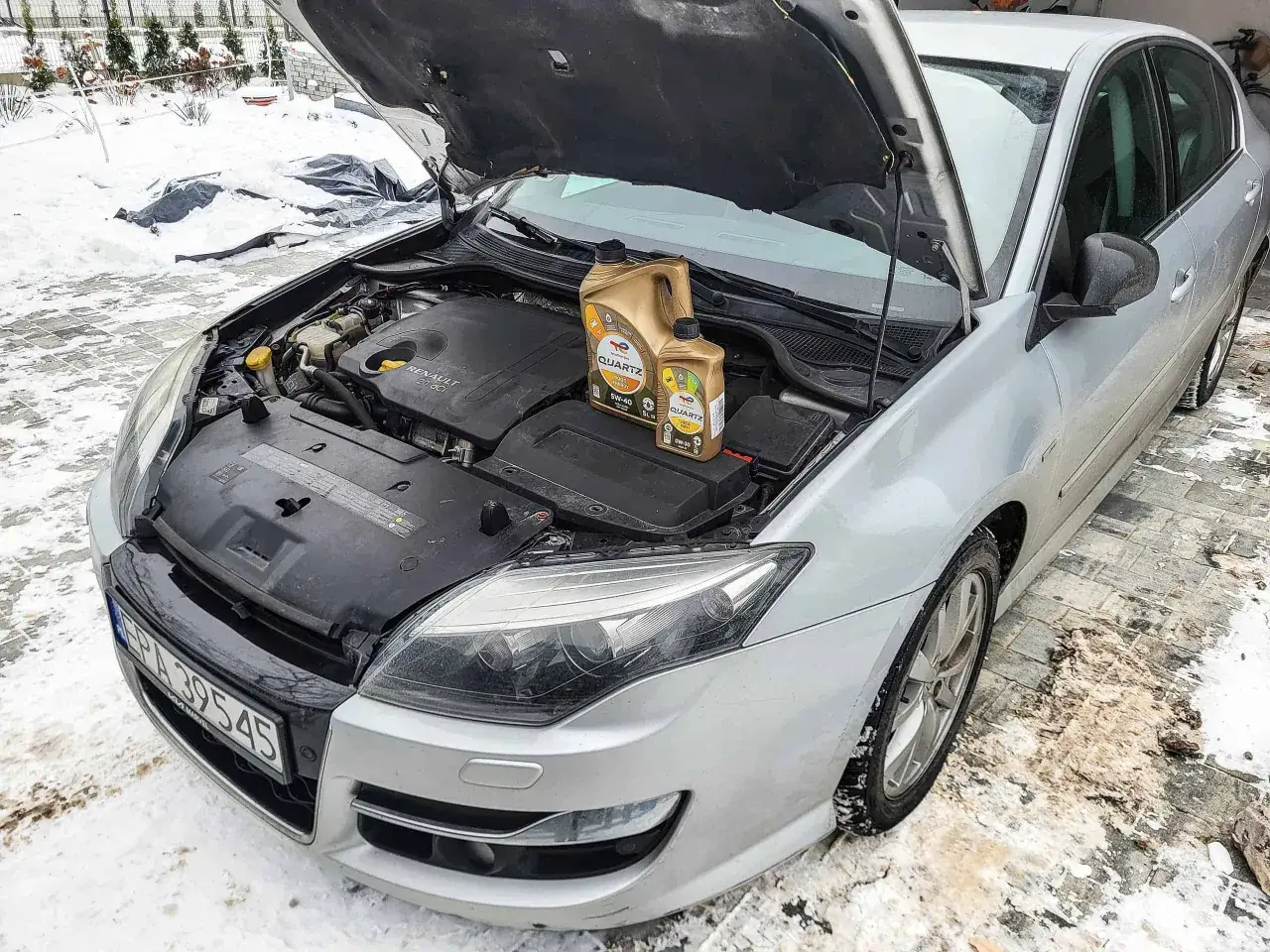 Pierwsza wymiana oleju w nowym aucie. Silnik Renault 2.0 dCi, dwa kanistry oleju Total Quartz. Zima na podjeździe.