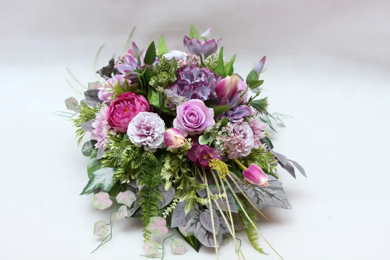Stroik z żywych kwiatów na cmentarz: różowe róże, piwonie, tulipany i hortensje. Piękna kompozycja na grób.