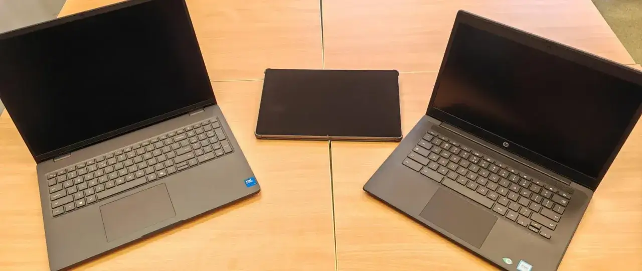 Dwa laptopy i tablet leżą na drewnianym stole. Czy uczniowie dostaną laptopy?