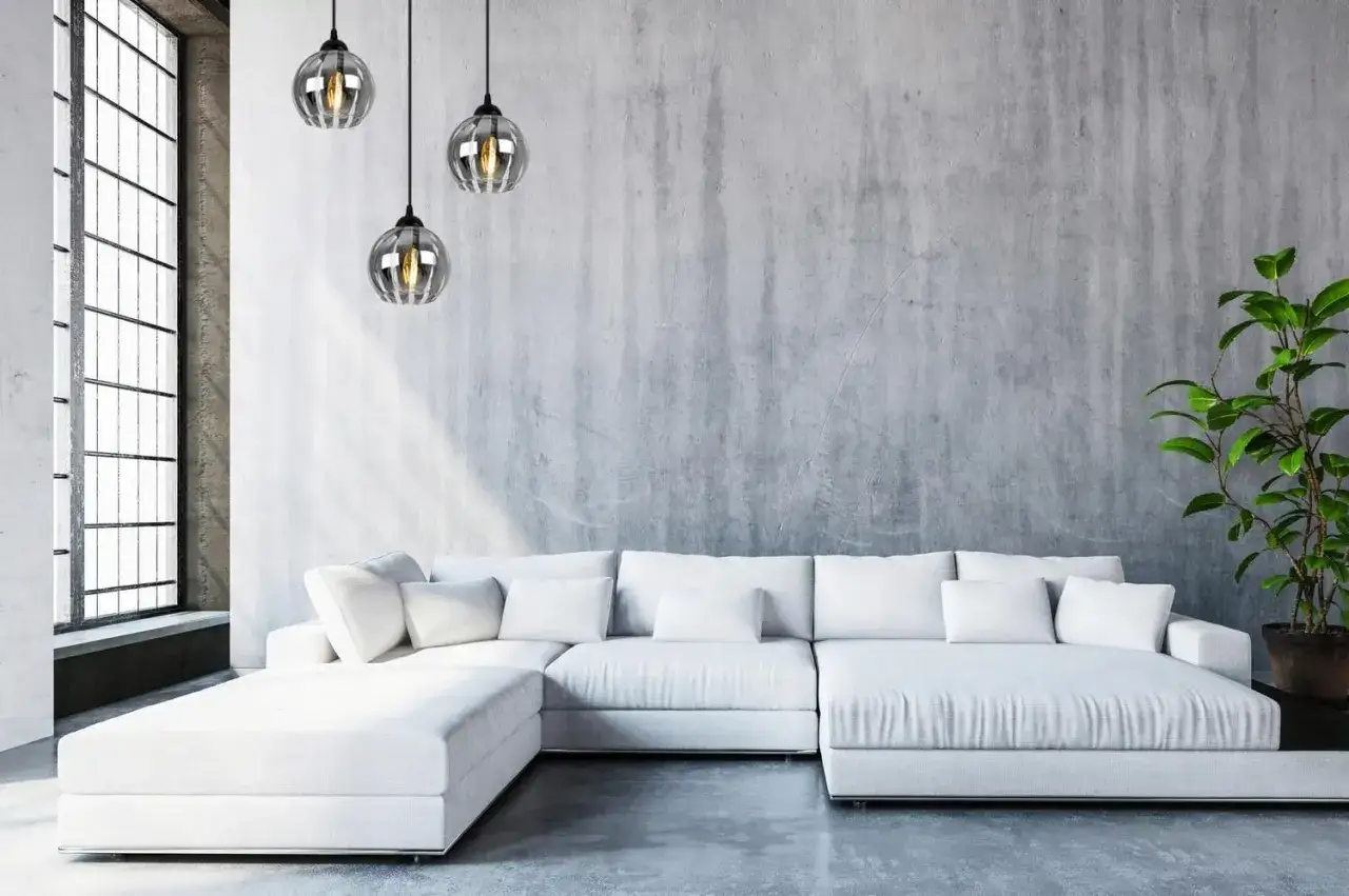 Nowoczesne wnętrze z białym narożnikiem i trzema wiszącymi lampami kule chrom.