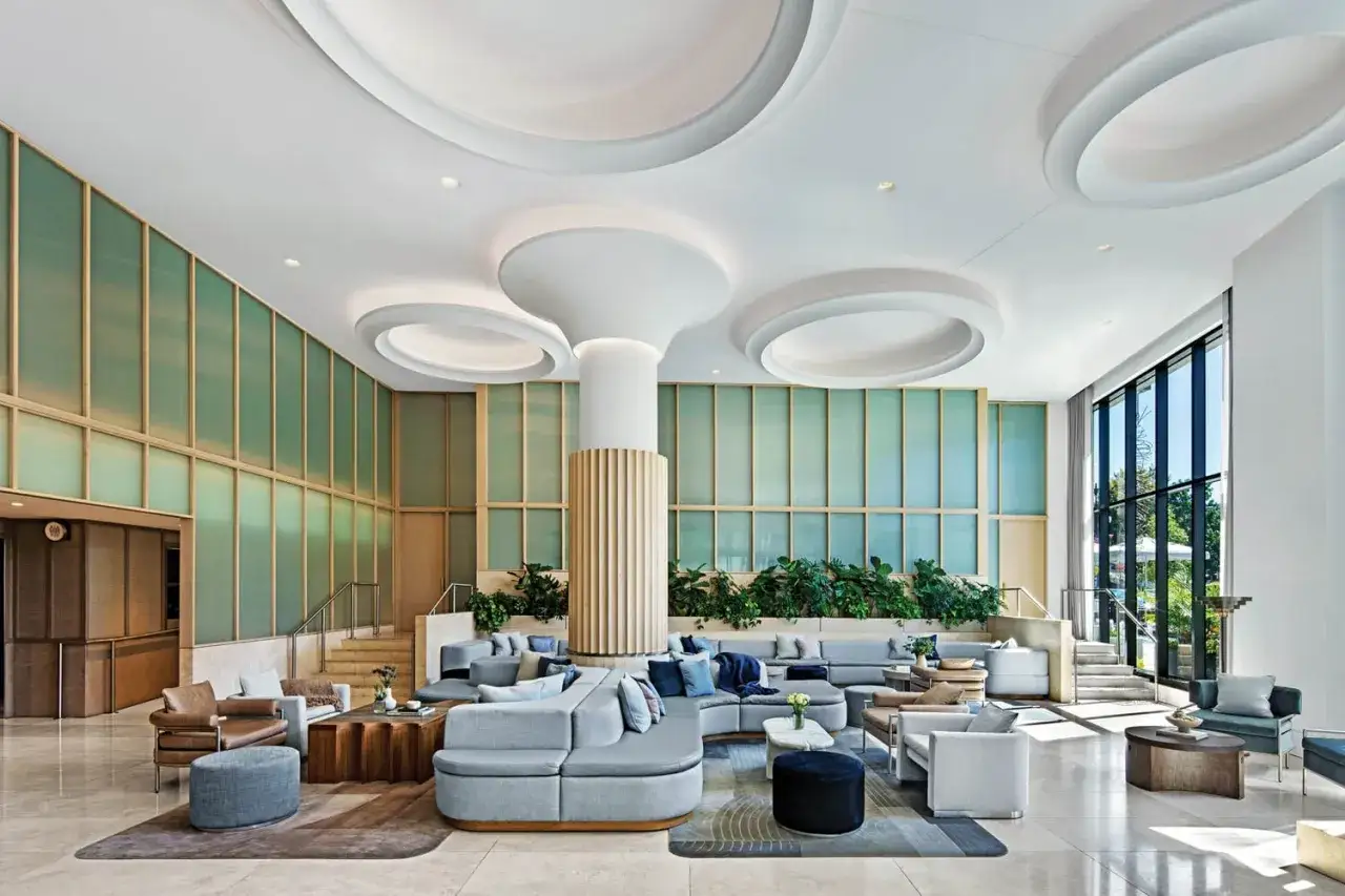 Nowoczesny hotel butikowy co to? Jasne, przestronne lobby z wygodnymi sofami, designerskimi meblami i zielenią.