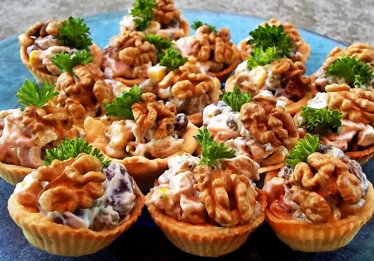 Pyszne sałatki finger food w kruchych babeczkach, udekorowane orzechami włoskimi i natką pietruszki. Idealne na przyjęcie!