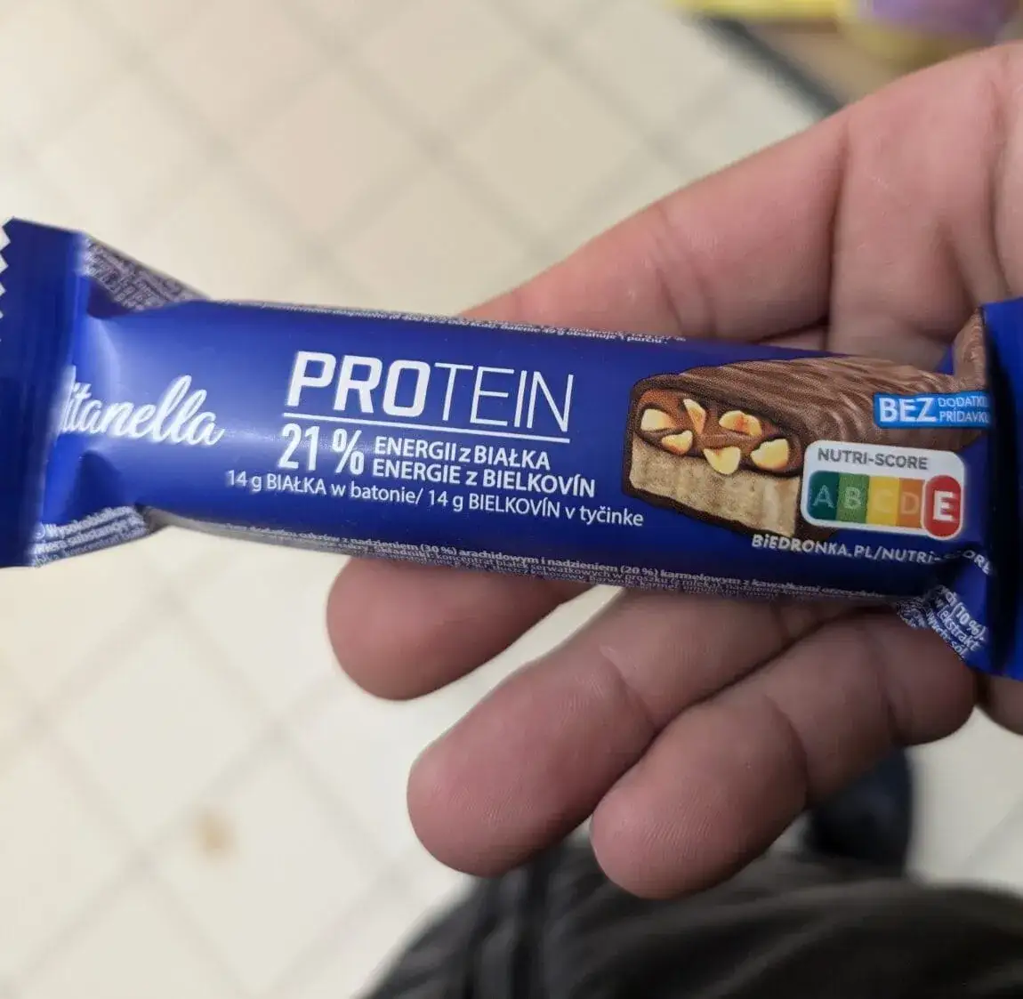 osoba jedząca baton proteinowy po treningu, korzyści z białka