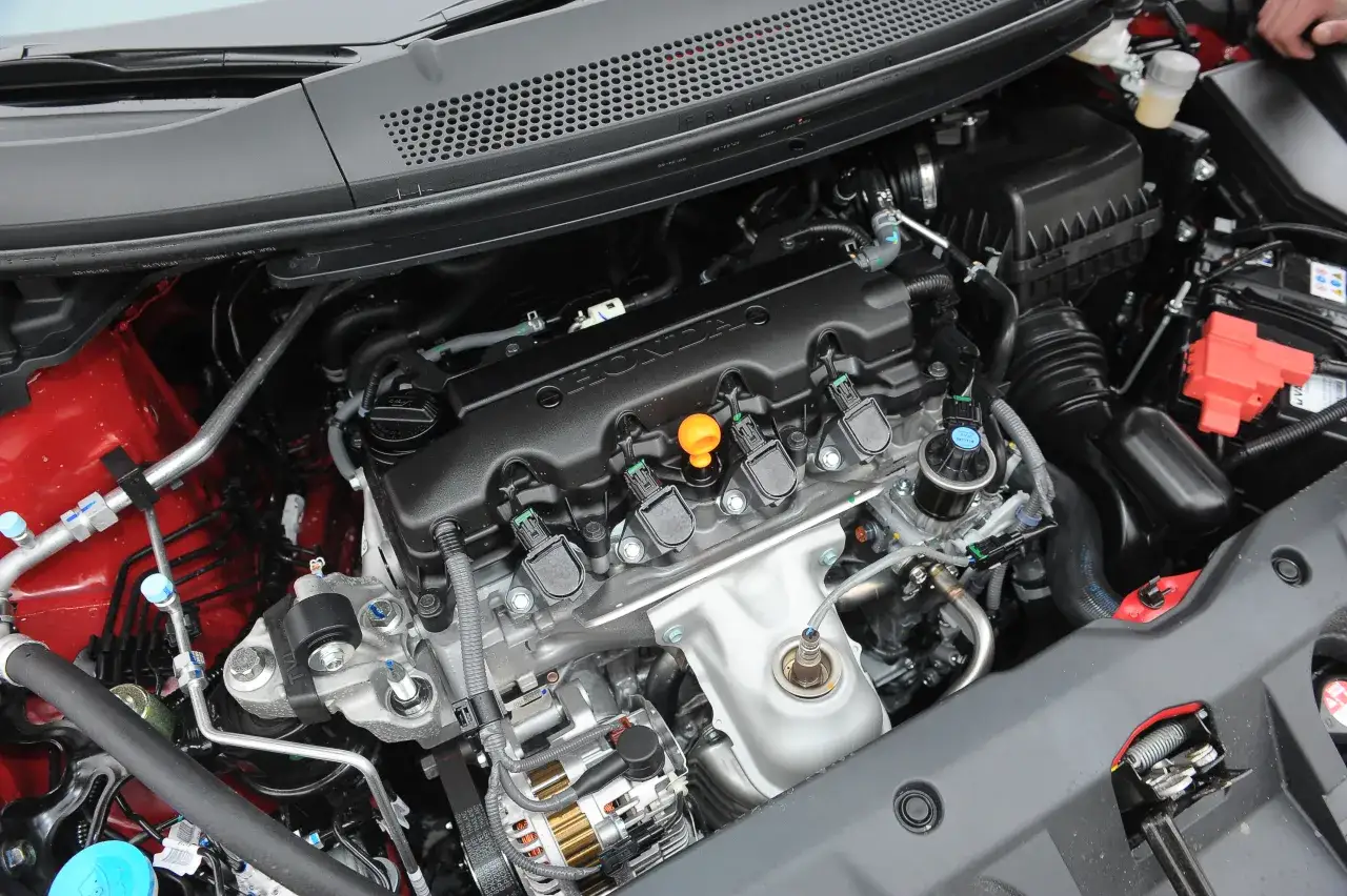 Silnik Hondy z niezniszczalnymi silnikami benzynowymi. Widoczne przewody, cewki zapłonowe i alternator.