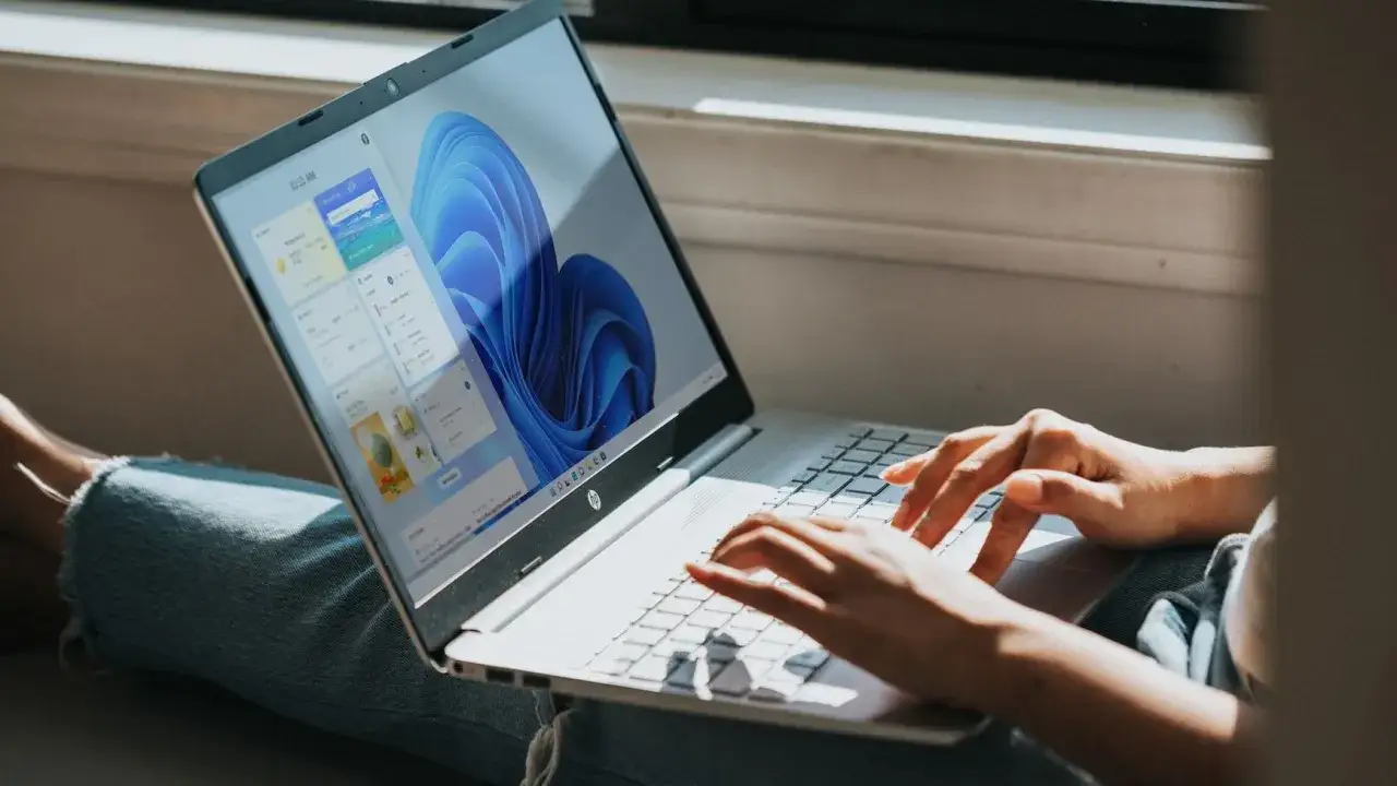 Osoba na laptopie z systemem Windows 11 szuka informacji, jak zmienić typ pliku, aby dostosować go do swoich potrzeb.
