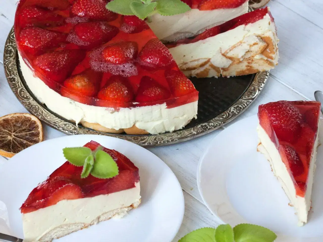 Sernik z wiaderka z truskawkami i galaretką, udekorowany miętą. Idealny deser na lato.