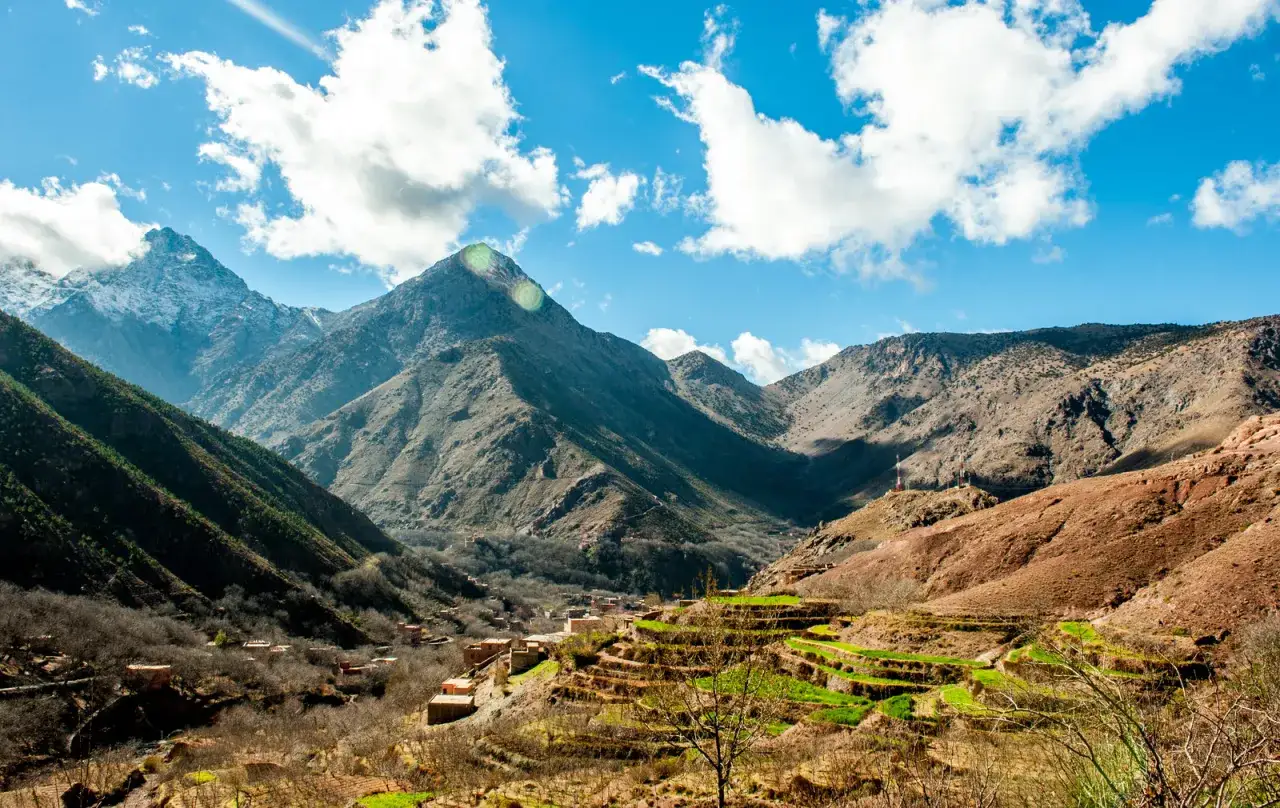 Widok na dolinę w g&oacute;rach Atlas w Maroku, z tarasowymi polami i tradycyjnymi domami.
