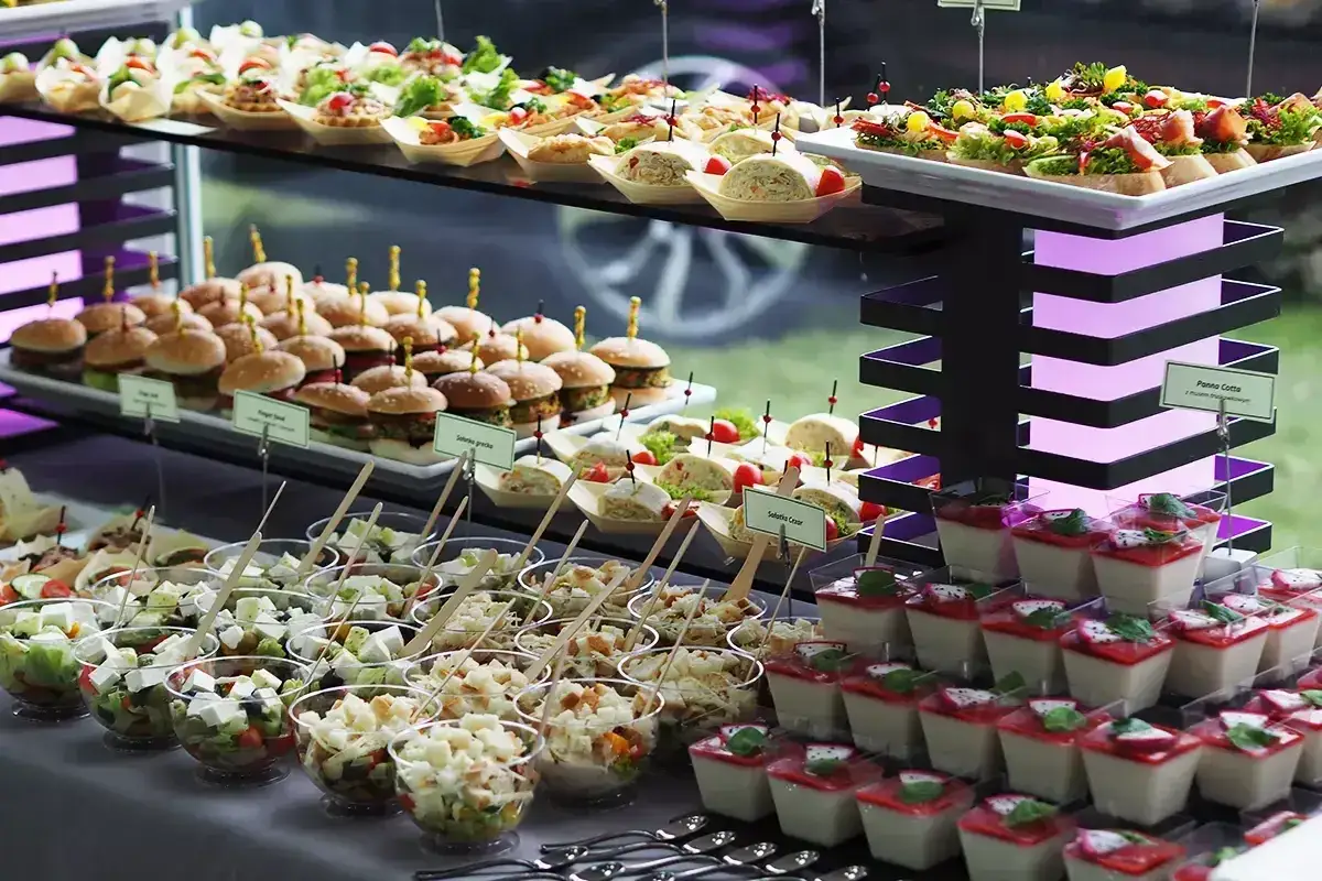 Elegancki catering do domu: mini burgery, sałatki w kubeczkach, kanapeczki i panna cotta.