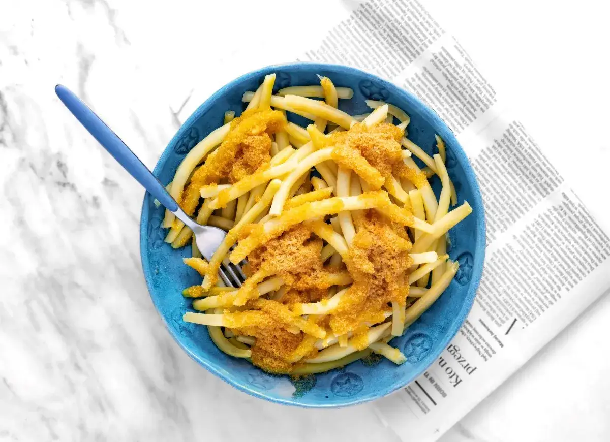 Ż&oacute;łta fasolka szparagowa z bułką tartą na talerzu