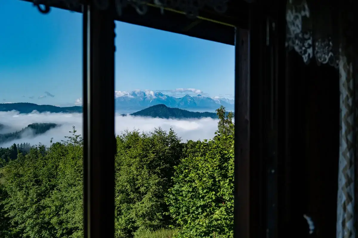 Widok z okna na g&oacute;ry i morze chmur. Planujesz pobyt w bac&oacute;wce pod Bereśnikiem? Sprawdź cennik!