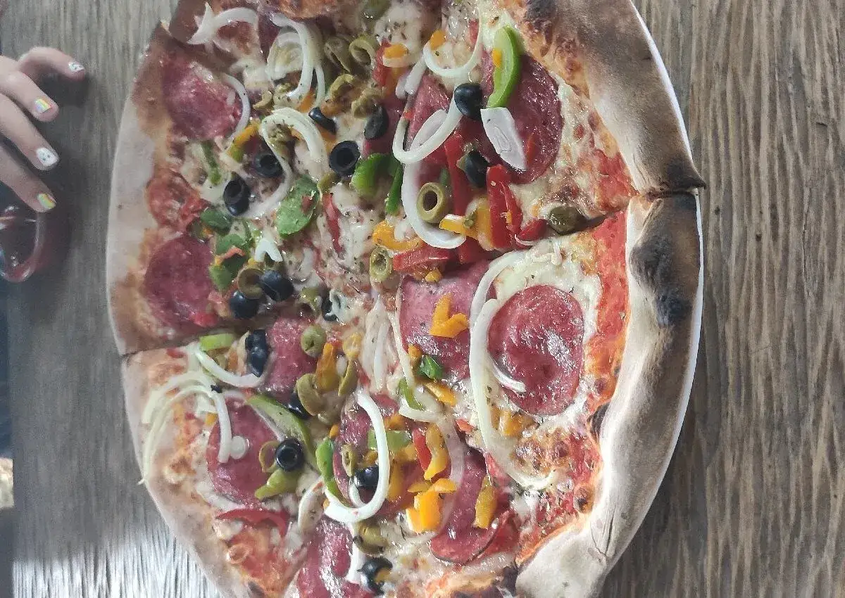 Pyszna pizza z salami, oliwkami i papryką z restauracji Gwarek Polańczyk. Idealna na rodzinny obiad.